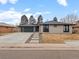 Charming single-story home featuring a modern garage door, inviting walkway, and updated exterior paint at 3049 S Vine St, Denver, CO 80210