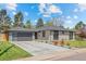 Beautiful exterior with a manicured lawn, mature trees, and concrete driveway at 3049 S Vine St, Denver, CO 80210