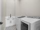 Well-lit laundry room with white cabinets, sink, and modern machines at 3049 S Vine St, Denver, CO 80210