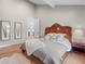 Comfortable main bedroom with wood floors, soft decor and a view to the ensuite bathroom at 3049 S Vine St, Denver, CO 80210