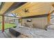 Covered outdoor patio with an outdoor kitchen, ceiling fan, and comfortable seating at 3049 S Vine St, Denver, CO 80210