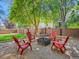 Backyard features a fire pit with Adirondack chairs and a fenced yard with lush landscaping at 13895 Sandtrap Cir, Broomfield, CO 80023