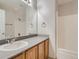 This bathroom features a vanity, a large mirror, and a shower and tub combo at 13895 Sandtrap Cir, Broomfield, CO 80023
