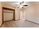 Bright bedroom showcasing a ceiling fan, closet space, and neutral carpet at 15491 E Wyoming Dr # A, Aurora, CO 80017
