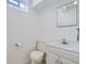 Neat half-bath featuring a pedestal sink, square mirror, and minimalist design elements at 283 Garland Dr, Northglenn, CO 80233