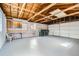 Spacious garage with overhead lighting, exposed rafter beams and ample room for vehicles or storage at 283 Garland Dr, Northglenn, CO 80233