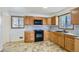 Functional kitchen with wooden cabinets, tile backsplash, and modern appliances perfect for cooking at 283 Garland Dr, Northglenn, CO 80233