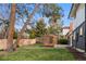 A beautiful backyard showcasing a lush green lawn, mature trees, and a charming pergola at 1660 S Kingston Way, Aurora, CO 80012