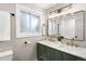 Stylish bathroom featuring a green vanity with double sinks and modern black and gold fixtures at 1660 S Kingston Way, Aurora, CO 80012
