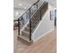 Modern staircase with black railings and light wood steps at 1660 S Kingston Way, Aurora, CO 80012