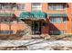 Charming brick building entrance featuring an awning and well-maintained landscaping at 85 N Grant St # 30, Denver, CO 80203