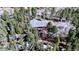 Mountain home with a deck situated amongst a dense forest with the access road visible at 10439 Christopher Dr, Conifer, CO 80433