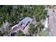 Secluded mountain home with a wrap-around deck surrounded by lush forest and a driveway leading to an attached garage at 10439 Christopher Dr, Conifer, CO 80433