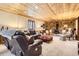 Finished basement with wood ceiling, brick accents, and comfortable seating, perfect for relaxation at 10439 Christopher Dr, Conifer, CO 80433