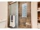 Bathroom features tiled walls, a shower, and a glass block window for privacy and natural light at 10439 Christopher Dr, Conifer, CO 80433
