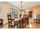 Well-lit dining room featuring a rustic wooden table set for a meal, adjacent to a wood-paneled wall at 10439 Christopher Dr, Conifer, CO 80433
