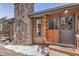Charming log cabin entrance with a stone chimney, wooden door, and a welcoming 'welcome' mat at 10439 Christopher Dr, Conifer, CO 80433