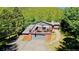 Log home with deck, garage, stone chimney, and hillside landscape at 10439 Christopher Dr, Conifer, CO 80433