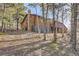 Charming log cabin with a stone chimney, nestled among tall trees at 10439 Christopher Dr, Conifer, CO 80433