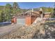 A spacious garage with a large deck above, showcasing a blend of functionality and outdoor living space at 10439 Christopher Dr, Conifer, CO 80433