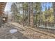 Back yard bordered by trees, offering a private outdoor space at 10439 Christopher Dr, Conifer, CO 80433