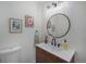 A half-bath with a modern vanity, framed art and toilet is perfect for guests at 5250 Cody St, Arvada, CO 80002