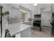 Well-lit kitchen features white cabinets, a modern backsplash, and a breakfast bar at 5250 Cody St, Arvada, CO 80002