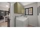 Efficient laundry room with newer appliances, ample storage, and a convenient window at 5250 Cody St, Arvada, CO 80002