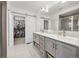 Bathroom featuring double vanity, tiled floors, and a closet with a sliding door at 11048 Rifle Ct, Commerce City, CO 80022