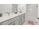 Clean bathroom with dual sinks, modern fixtures, plenty of natural light, and a bathtub shower combo at 11048 Rifle Ct, Commerce City, CO 80022