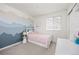 Charming bedroom with custom mountain mural and soft pink bedding, features ample sunlight at 11048 Rifle Ct, Commerce City, CO 80022