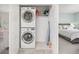Conveniently located upstairs laundry closet, with a washer and dryer, shelving, and a view into the bedroom at 11048 Rifle Ct, Commerce City, CO 80022