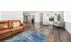 Open-concept living room with hardwood floors, leather sofa, and seamless flow to dining at 11048 Rifle Ct, Commerce City, CO 80022