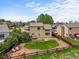 Aerial view of a two-story home with a landscaped backyard, stone patio, lush lawn, and a charming outdoor seating area at 4963 Collingswood Dr, Highlands Ranch, CO 80130