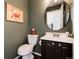 Charming powder room with stylish round mirror, dark vanity, and decorative wall art at 4963 Collingswood Dr, Highlands Ranch, CO 80130