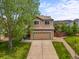 Two story home with a well manicured lawn, mature tree, and a two car garage at 4963 Collingswood Dr, Highlands Ranch, CO 80130
