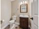 Bathroom with vanity, toilet, and dark floors, next to a door at 13271 Holly St # D, Thornton, CO 80241