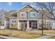 Two-story townhome featuring stone accents, a red front door, and a well-maintained front lawn at 13271 Holly St # D, Thornton, CO 80241