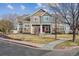 Two-story townhome featuring stone accents, a red front door, and a well-maintained front lawn at 13271 Holly St # D, Thornton, CO 80241