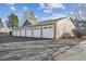 Row of detached garages showing white doors, stone accents, and ample parking space on a sunny day at 13271 Holly St # D, Thornton, CO 80241