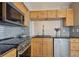 Updated kitchen with stainless steel appliances, wood cabinets, and tile backsplash at 13271 Holly St # D, Thornton, CO 80241