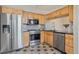 Updated kitchen with stainless steel appliances, wood cabinets, and tile backsplash at 13271 Holly St # D, Thornton, CO 80241
