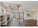 Living room with fireplace, hardwood floors, large windows, and a partial view into the kitchen at 13271 Holly St # D, Thornton, CO 80241