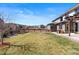 Expansive backyard featuring a lush lawn, wooden fence, and views of neighboring houses and open spaces at 18926 W 93Rd Ave, Arvada, CO 80007