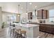 Modern kitchen featuring quartz countertops, stainless steel appliances, and a large island with barstool seating at 18926 W 93Rd Ave, Arvada, CO 80007