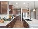 Spacious kitchen with a large island, modern appliances, dark cabinetry, and quartz countertops at 18926 W 93Rd Ave, Arvada, CO 80007