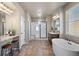 Bright primary bathroom with dual sinks, a soaking tub, walk-in shower, and modern fixtures at 18926 W 93Rd Ave, Arvada, CO 80007