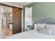 Comfortable bedroom with a rustic sliding barn door leading to the luxurious ensuite bathroom at 18926 W 93Rd Ave, Arvada, CO 80007