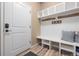 Mudroom with white bench seating, cubbies, coat hooks, and wood-look floors offers style and function at 18926 W 93Rd Ave, Arvada, CO 80007