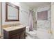 Bathroom featuring a granite vanity, modern fixtures, and a shower with decorative tile at 4591 S Pennsylvania St, Englewood, CO 80113